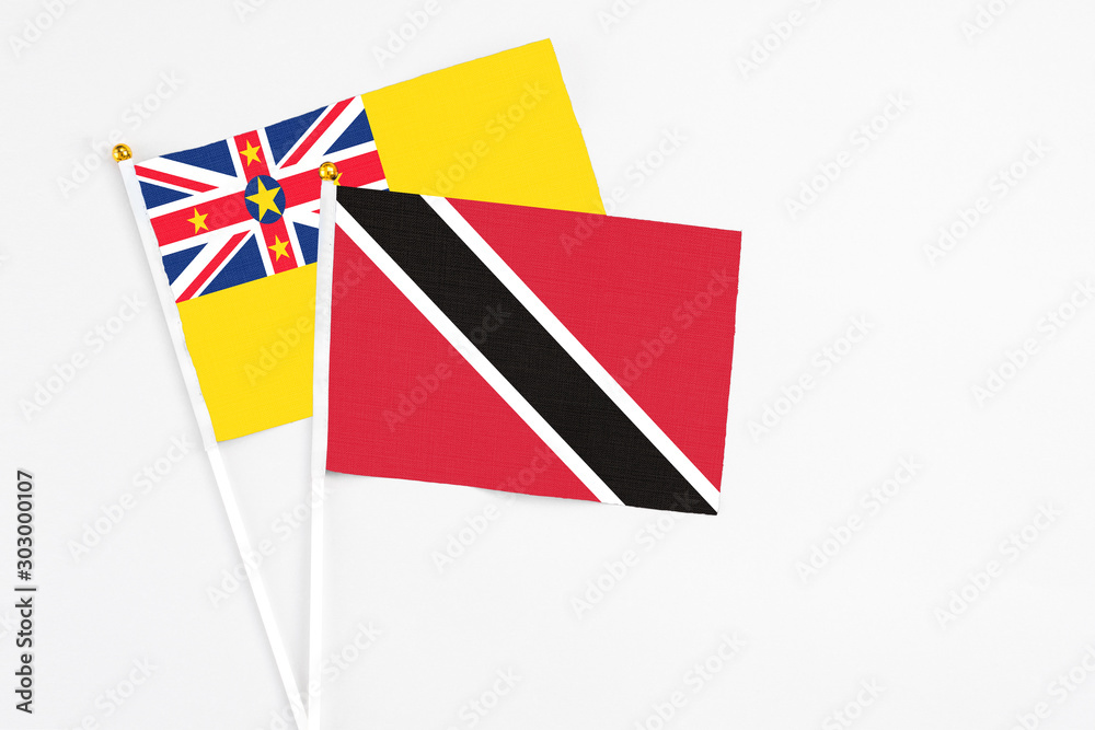 Trinidad And Tobago and Niue stick flags on white background. High quality fabric, miniature national flag. Peaceful global concept.White floor for copy space. Trinidad And Tobago and Niue stick flags on white background. High quality fabric, miniature national flag. Peaceful global concept.White floor for copy space.
