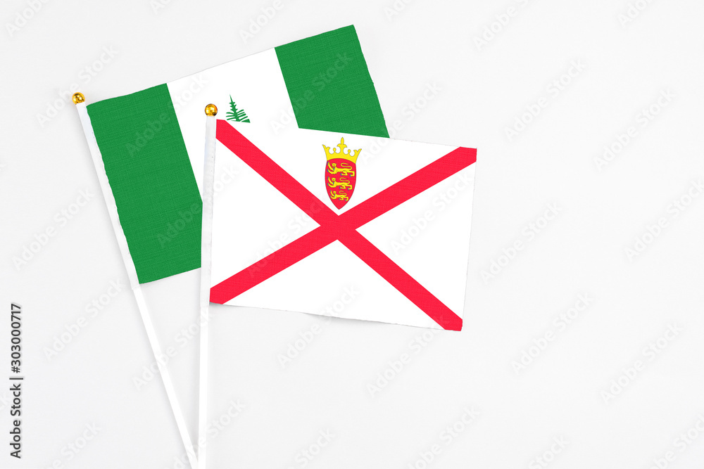 Jersey and Norfolk Island stick flags on white background. High quality fabric, miniature national flag. Peaceful global concept.White floor for copy space. Jersey and Norfolk Island stick flags on white background. High quality fabric, miniature national flag. Peaceful global concept.White floor for copy space.