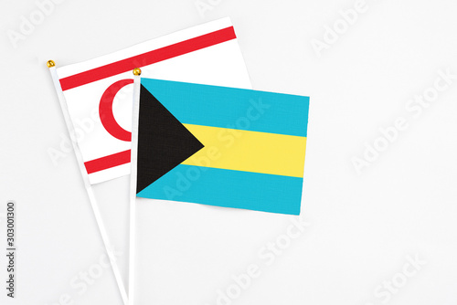 Bahamas and Northern Cyprus stick flags on white background. High quality fabric  miniature national flag. Peaceful global concept.White floor for copy space.