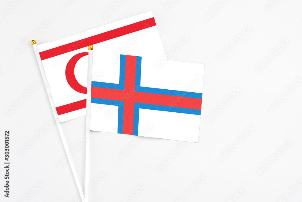 Faroe Islands and Northern Cyprus stick flags on white background. High quality fabric, miniature national flag. Peaceful global concept.White floor for copy space.