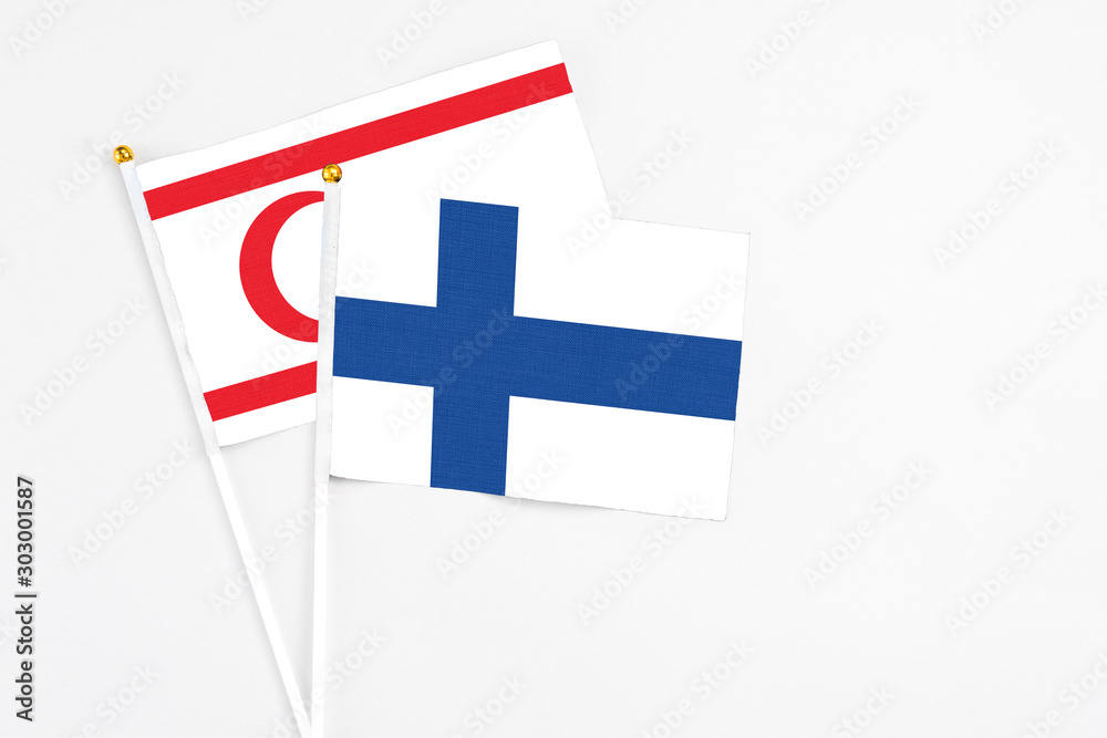 Finland and Northern Cyprus stick flags on white background. High quality fabric, miniature national flag. Peaceful global concept.White floor for copy space.