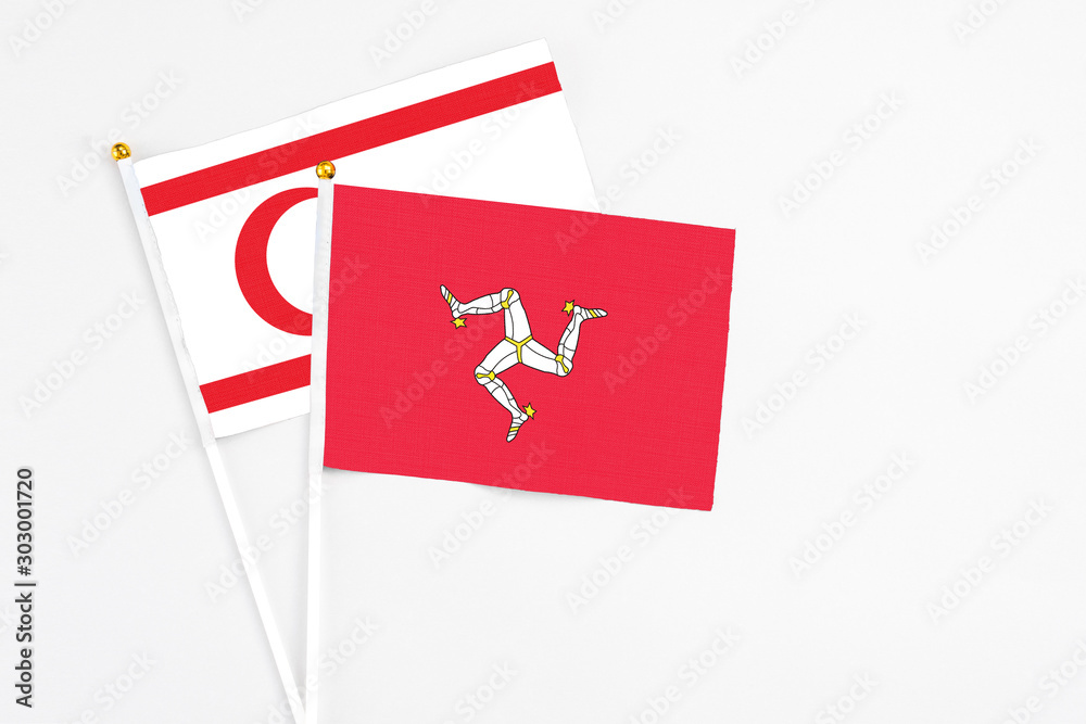 Isle Of Man and Northern Cyprus stick flags on white background. High quality fabric, miniature national flag. Peaceful global concept.White floor for copy space.