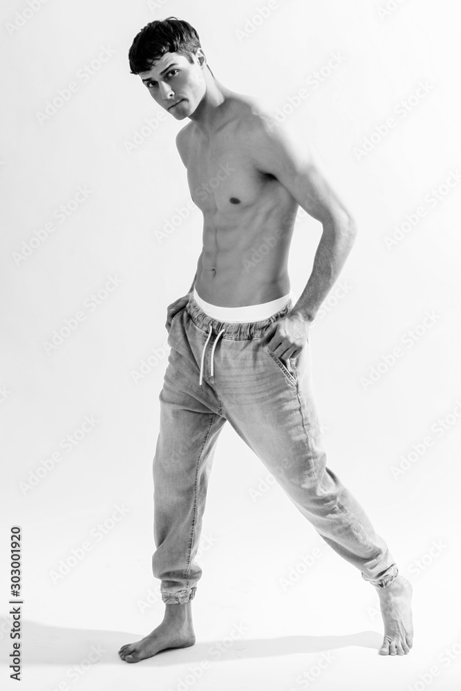 Black and White Muscle strong beautiful stripped male model in denim jeans on white isolated font background with shadow Black and White Muscle strong beautiful stripped male model in denim jeans on white isolated font background with shadow