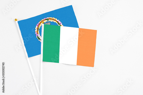 Ireland and Northern Mariana Islands stick flags on white background. High quality fabric, miniature national flag. Peaceful global concept.White floor for copy space.