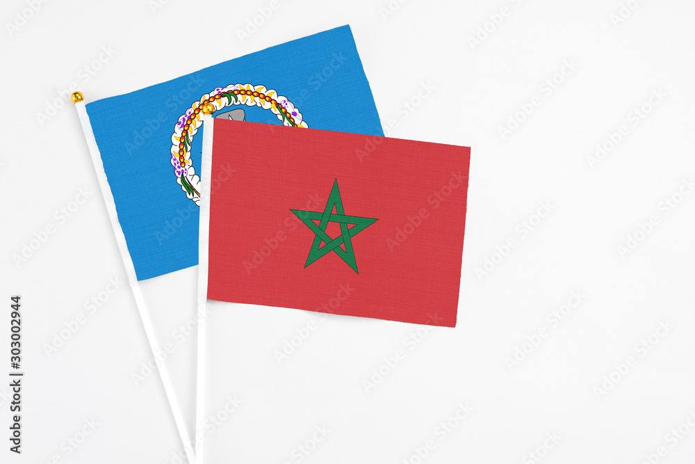 Morocco and Northern Mariana Islands stick flags on white background. High quality fabric, miniature national flag. Peaceful global concept.White floor for copy space.