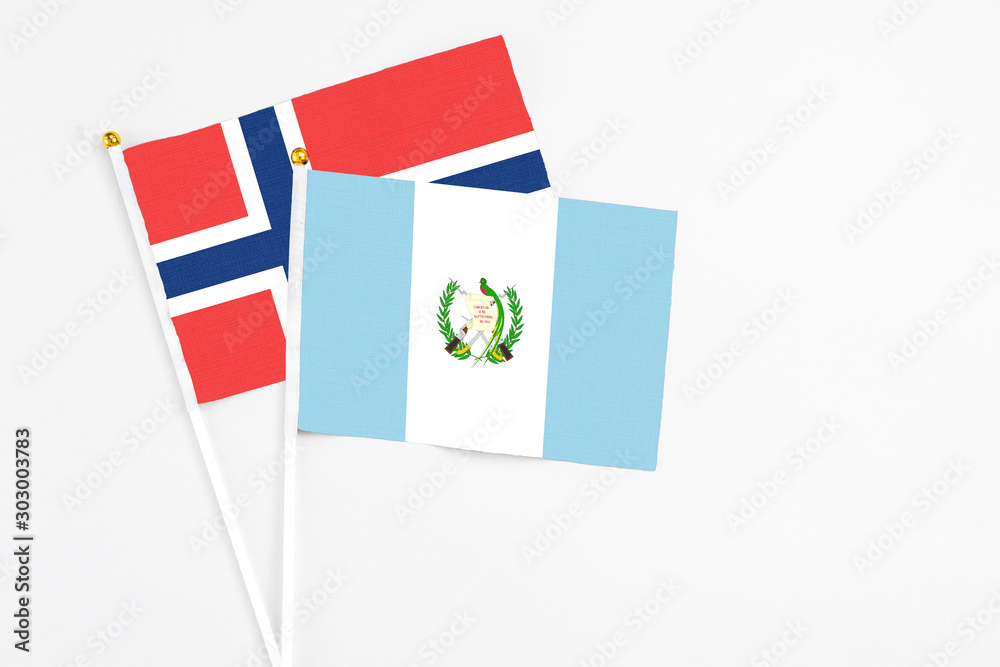 Guatemala and Norway stick flags on white background. High quality fabric, miniature national flag. Peaceful global concept.White floor for copy space. Guatemala and Norway stick flags on white background. High quality fabric, miniature national flag. Peaceful global concept.White floor for copy space.