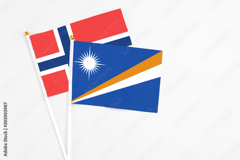 Marshall Islands and Norway stick flags on white background. High quality fabric, miniature national flag. Peaceful global concept.White floor for copy space. Marshall Islands and Norway stick flags on white background. High quality fabric, miniature national flag. Peaceful global concept.White floor for copy space.