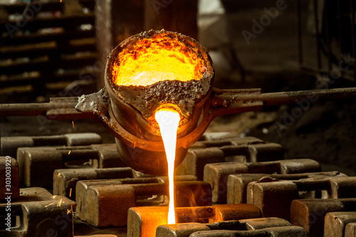metal casting process with red high temperature fire in metal part factory photo