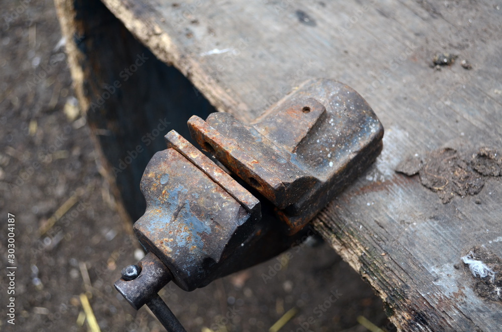 A old bench metal vise grip over brown background