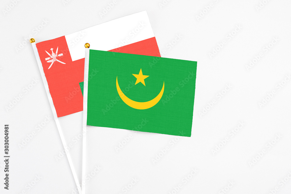 Mauritania and Oman stick flags on white background. High quality fabric, miniature national flag. Peaceful global concept.White floor for copy space. Mauritania and Oman stick flags on white background. High quality fabric, miniature national flag. Peaceful global concept.White floor for copy space.