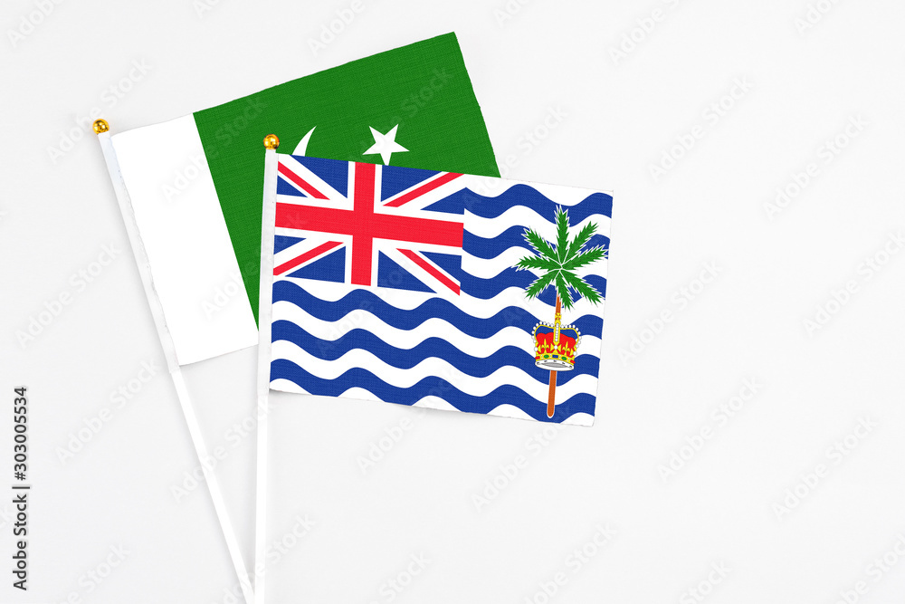 Fototapeta premium British Indian Ocean Territory and Pakistan stick flags on white background. High quality fabric, miniature national flag. Peaceful global concept.White floor for copy space.