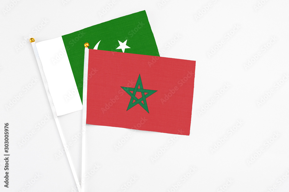 Morocco and Pakistan stick flags on white background. High quality fabric, miniature national flag. Peaceful global concept.White floor for copy space. Morocco and Pakistan stick flags on white background. High quality fabric, miniature national flag. Peaceful global concept.White floor for copy space.