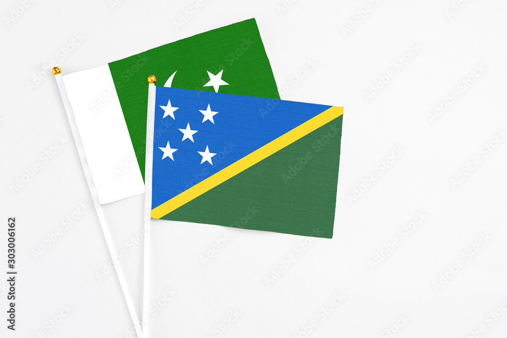 Solomon Islands and Pakistan stick flags on white background. High quality fabric, miniature national flag. Peaceful global concept.White floor for copy space. Solomon Islands and Pakistan stick flags on white background. High quality fabric, miniature national flag. Peaceful global concept.White floor for copy space.