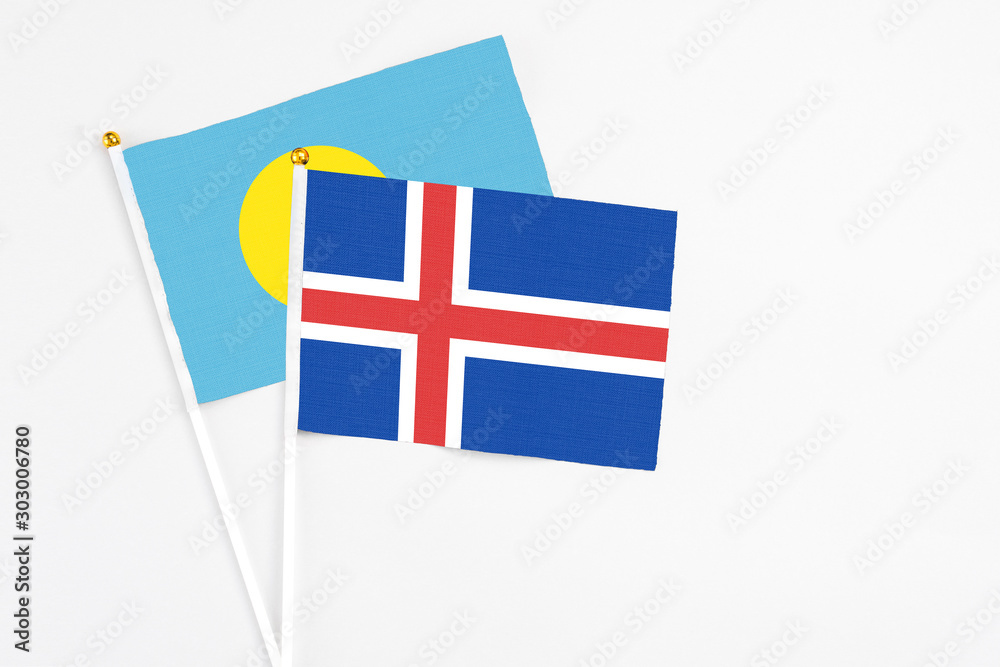 Iceland and Palau stick flags on white background. High quality fabric, miniature national flag. Peaceful global concept.White floor for copy space.