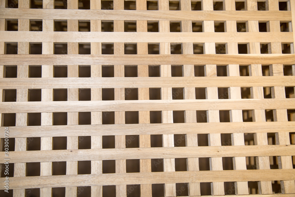 A lattice of bars of precious wood of light brown color. Backgrounds, structures, designs. A lattice of bars of precious wood of light brown color. Backgrounds, structures, designs.