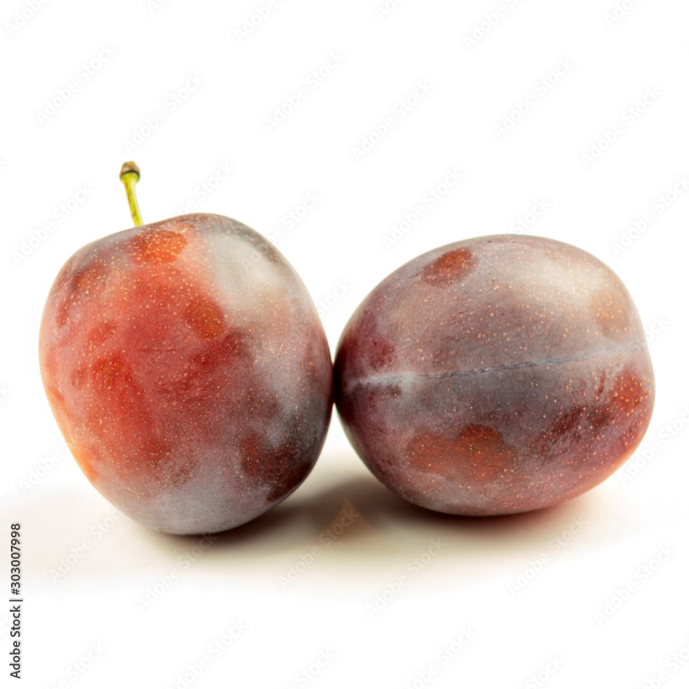 Obraz premium Fresh ripe purple plum on the white background closeup.