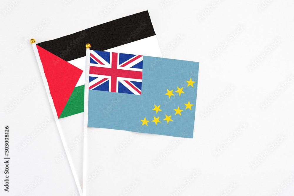 Fototapeta premium Tuvalu and Palestine stick flags on white background. High quality fabric, miniature national flag. Peaceful global concept.White floor for copy space.