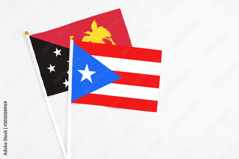 Puerto Rico and Papua New Guinea stick flags on white background. High quality fabric, miniature national flag. Peaceful global concept.White floor for copy space.