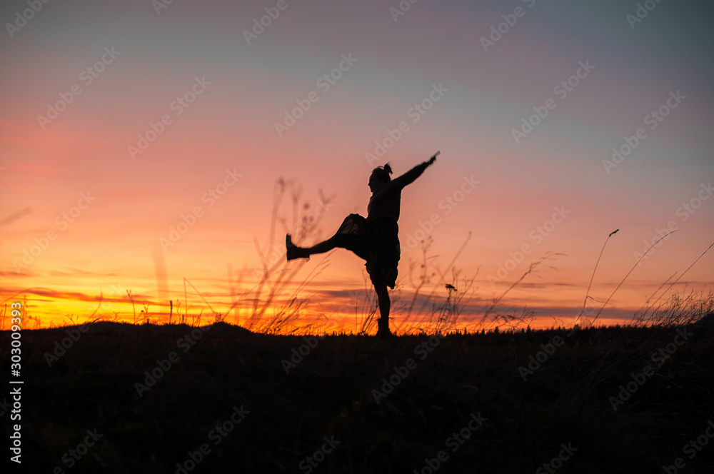 silhouette of a girl dancing on the background of a beautiful sunset