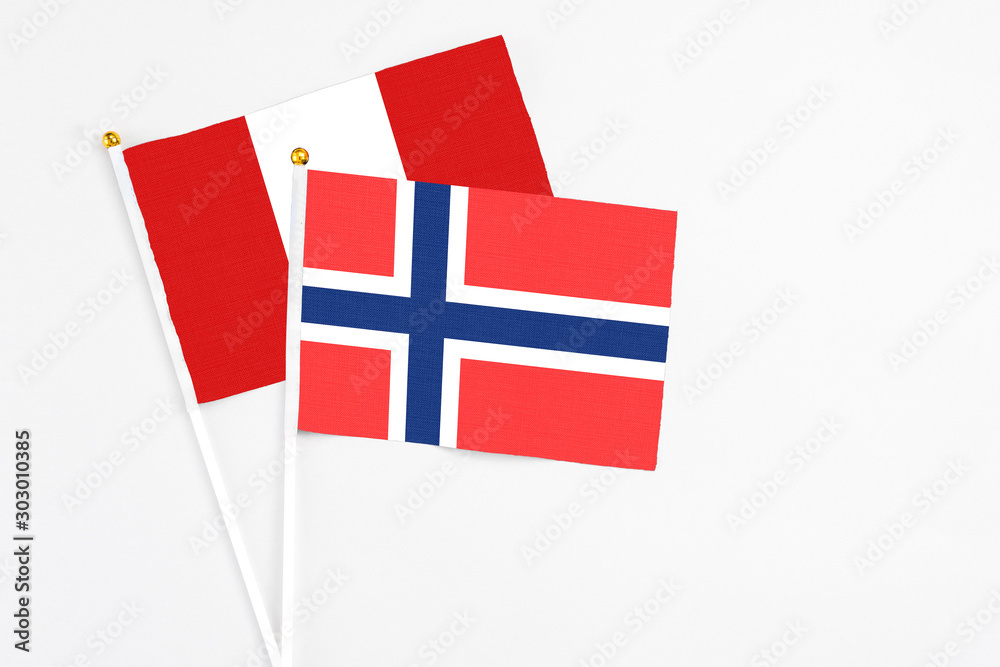 Bouvet Islands and Peru stick flags on white background. High quality fabric, miniature national flag. Peaceful global concept.White floor for copy space.