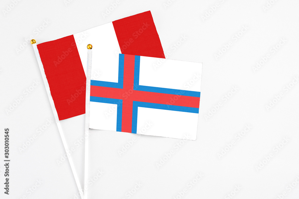 Faroe Islands and Peru stick flags on white background. High quality fabric, miniature national flag. Peaceful global concept.White floor for copy space.