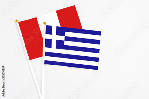 Greece and Peru stick flags on white background. High quality fabric, miniature national flag. Peaceful global concept.White floor for copy space.