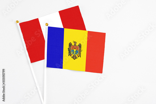 Moldova and Peru stick flags on white background. High quality fabric, miniature national flag. Peaceful global concept.White floor for copy space.