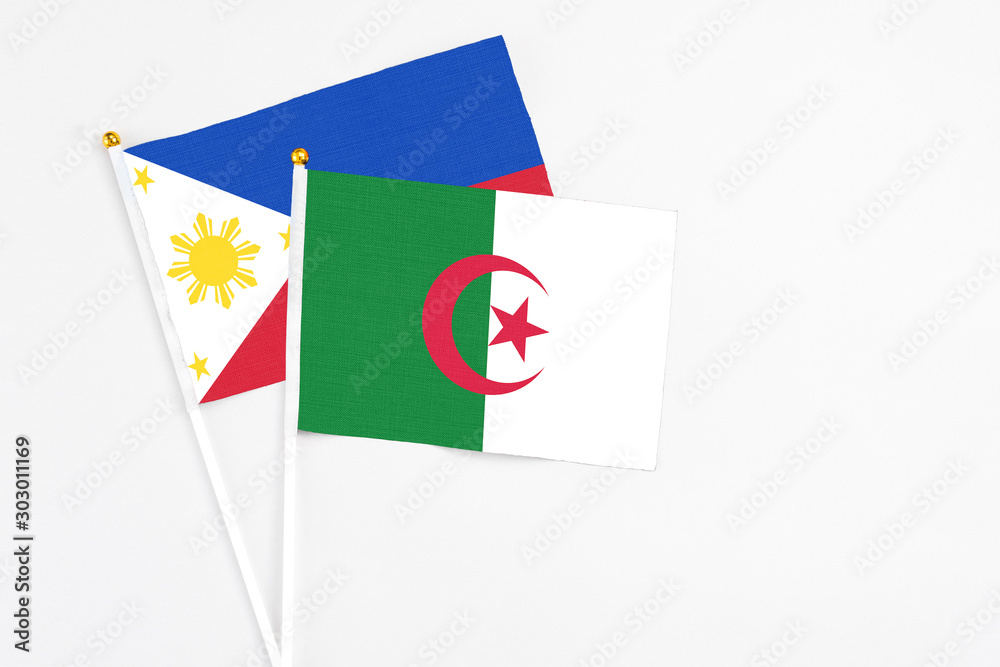 Algeria and Philippines stick flags on white background. High quality fabric, miniature national flag. Peaceful global concept.White floor for copy space. Algeria and Philippines stick flags on white background. High quality fabric, miniature national flag. Peaceful global concept.White floor for copy space.