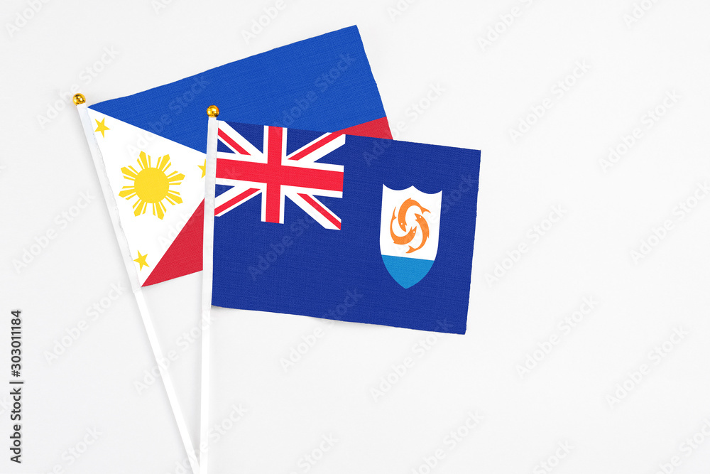 Fototapeta premium Anguilla and Philippines stick flags on white background. High quality fabric, miniature national flag. Peaceful global concept.White floor for copy space.