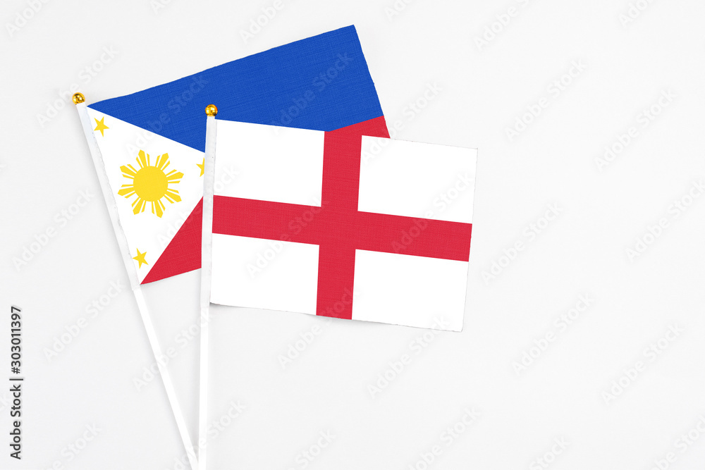 England and Philippines stick flags on white background. High quality fabric, miniature national flag. Peaceful global concept.White floor for copy space.