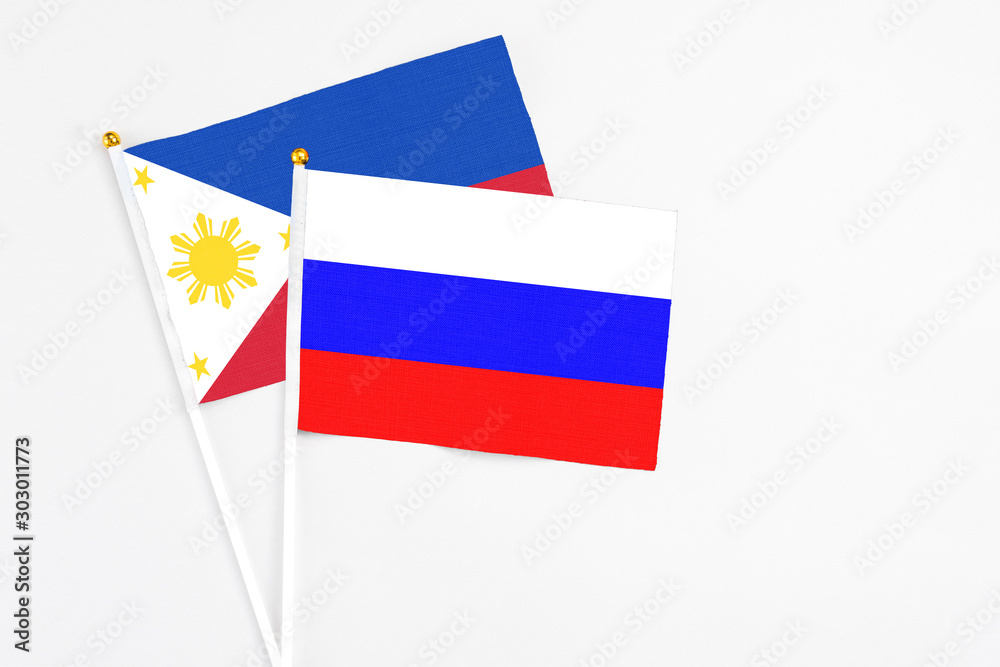 Russia and Philippines stick flags on white background. High quality fabric, miniature national flag. Peaceful global concept.White floor for copy space. Russia and Philippines stick flags on white background. High quality fabric, miniature national flag. Peaceful global concept.White floor for copy space.