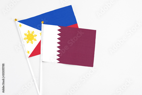 Qatar and Philippines stick flags on white background. High quality fabric, miniature national flag. Peaceful global concept.White floor for copy space.