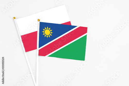 Free Download Namibia and Poland stick flags on white background. High quality fabric, miniature national flag. Peaceful global concept.White floor for copy space. - GFXLoad