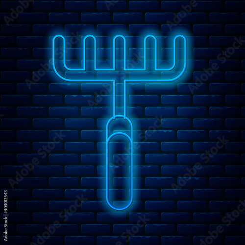 Glowing neon line Garden rake icon isolated on brick wall background. Tool for horticulture, agriculture, farming. Ground cultivator. Housekeeping equipment. Vector Illustration