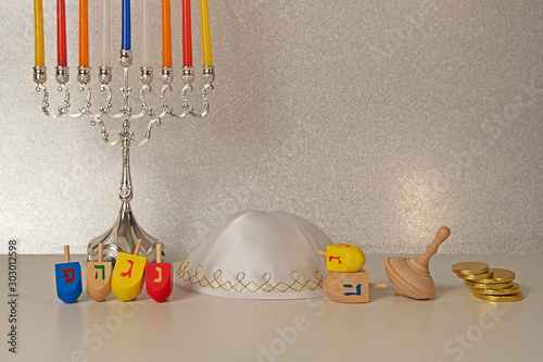 concept of of jewish religion holiday hanukkah with wooden spinning top toys (dreidel), traditional chandelier menorah,  scullcap (kipa) and chocolate coins photo