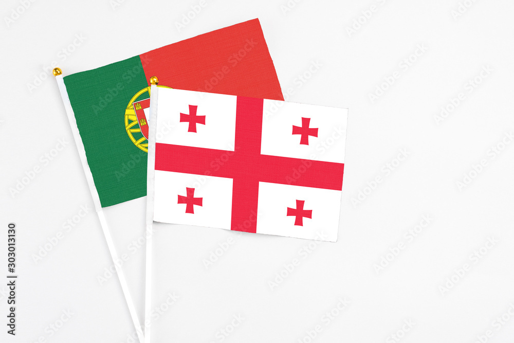 Georgia and Portugal stick flags on white background. High quality fabric, miniature national flag. Peaceful global concept.White floor for copy space. Georgia and Portugal stick flags on white background. High quality fabric, miniature national flag. Peaceful global concept.White floor for copy space.