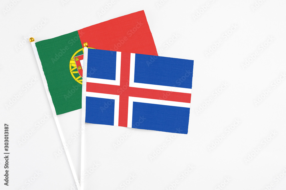 Iceland and Portugal stick flags on white background. High quality fabric, miniature national flag. Peaceful global concept.White floor for copy space.