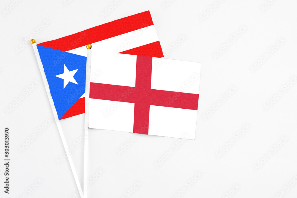 England and Puerto Rico stick flags on white background. High quality fabric, miniature national flag. Peaceful global concept.White floor for copy space.