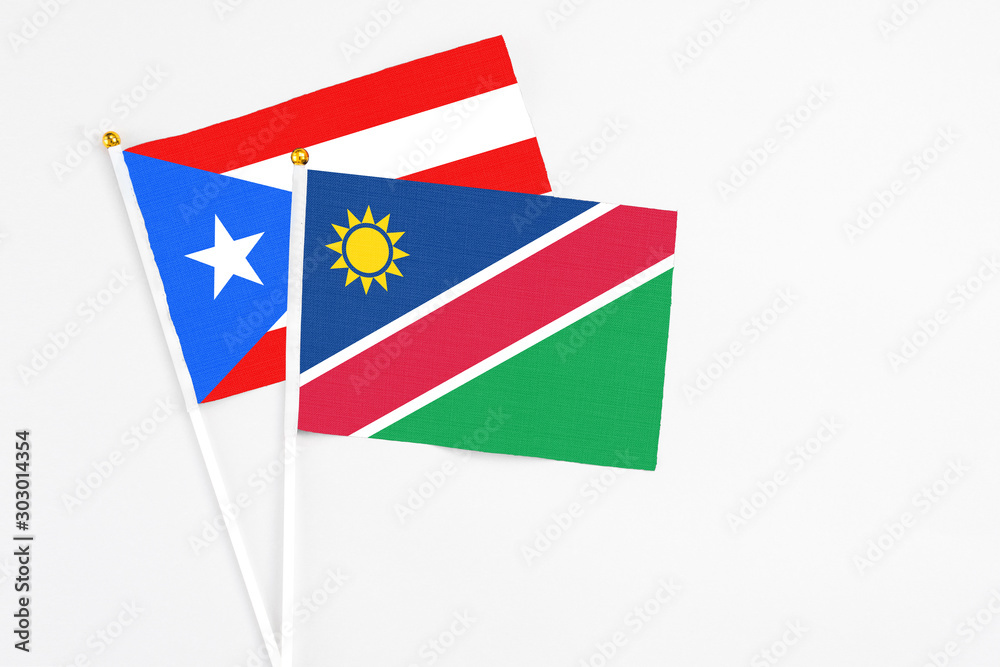 Namibia and Puerto Rico stick flags on white background. High quality fabric, miniature national flag. Peaceful global concept.White floor for copy space. Namibia and Puerto Rico stick flags on white background. High quality fabric, miniature national flag. Peaceful global concept.White floor for copy space.