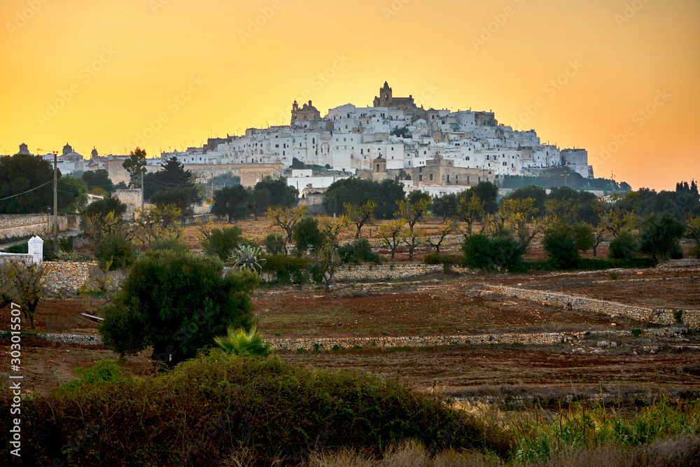 Cityscape of Ostuni Puglia Italy At Sunset With Olive Trees In The Foreground At Sunset