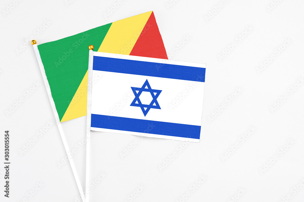 Obraz premium Israel and Republic Of The Congo stick flags on white background. High quality fabric, miniature national flag. Peaceful global concept.White floor for copy space.