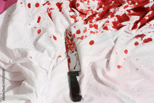 Bloody Knife on white bed sheets