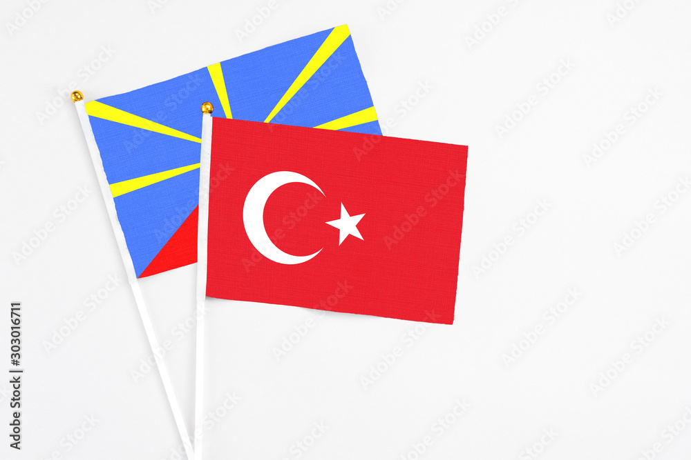 Turkey and Reunion stick flags on white background. High quality fabric, miniature national flag. Peaceful global concept.White floor for copy space.