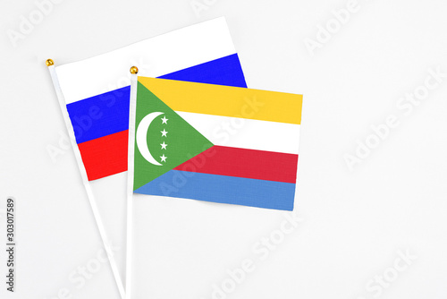 Free Download Comoros and Russia stick flags on white background. High quality fabric, miniature national flag. Peaceful global concept.White floor for copy space. - GFXLoad