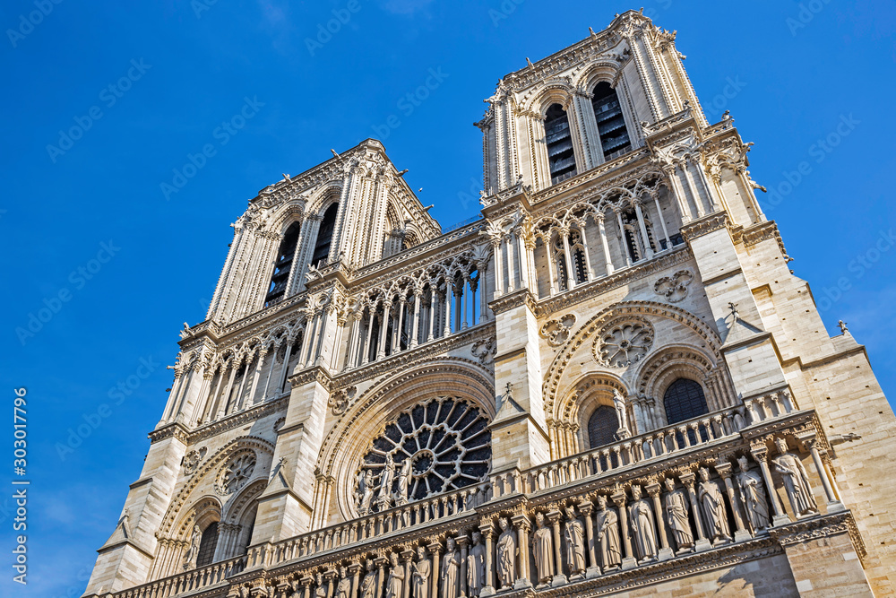 Facade of Cathedral Notre-Dame de Paris against blue sky in Paris, France