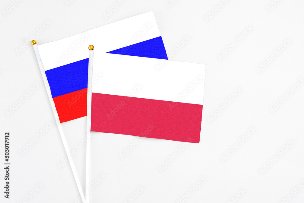 Poland and Russia stick flags on white background. High quality fabric, miniature national flag. Peaceful global concept.White floor for copy space. Poland and Russia stick flags on white background. High quality fabric, miniature national flag. Peaceful global concept.White floor for copy space.