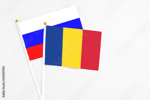 Romania and Russia stick flags on white background. High quality fabric, miniature national flag. Peaceful global concept.White floor for copy space.