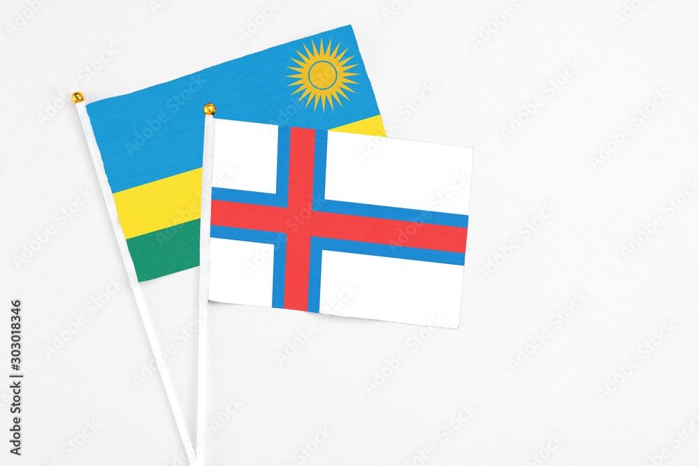 Faroe Islands and Rwanda stick flags on white background. High quality fabric, miniature national flag. Peaceful global concept.White floor for copy space. Faroe Islands and Rwanda stick flags on white background. High quality fabric, miniature national flag. Peaceful global concept.White floor for copy space.