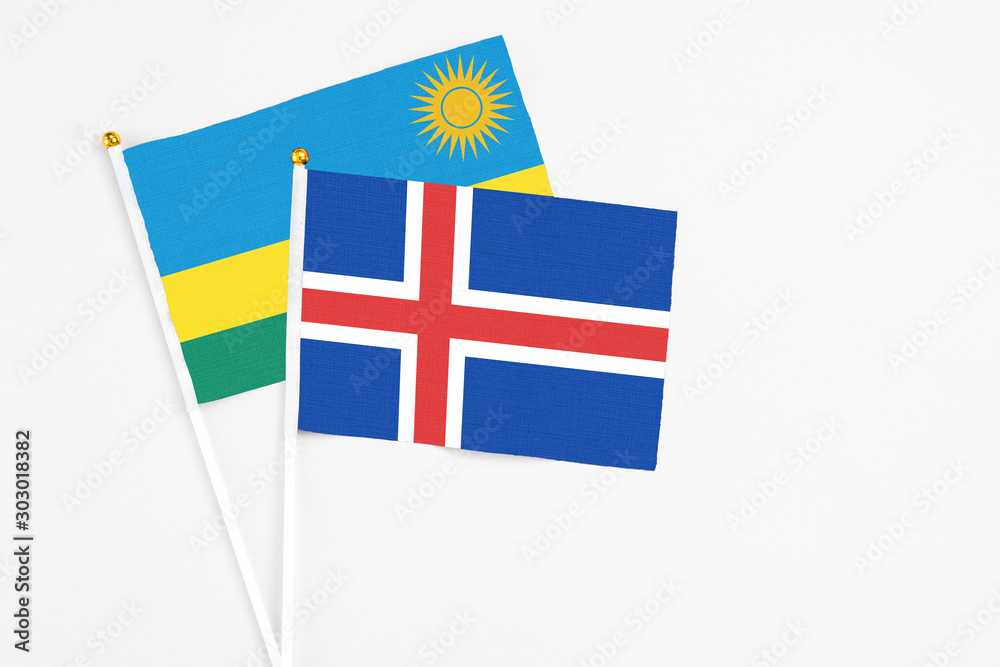 Iceland and Rwanda stick flags on white background. High quality fabric, miniature national flag. Peaceful global concept.White floor for copy space.