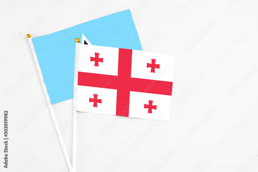 Georgia and Saint Lucia stick flags on white background. High quality fabric, miniature national flag. Peaceful global concept.White floor for copy space.